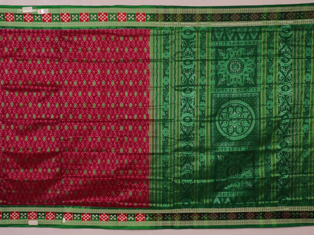 Close-up of magenta Sambalpuri silk saree fabric texture, showcasing intricate handloom weave and subtle motifs.