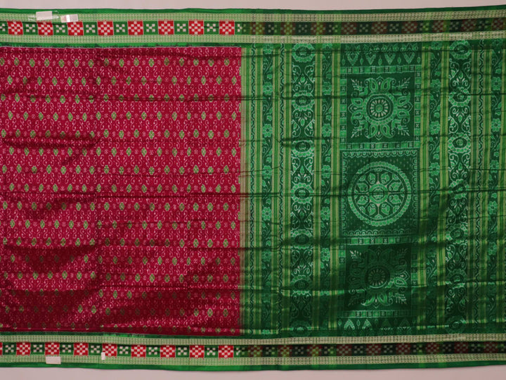 Close-up of magenta Sambalpuri silk saree fabric texture, showcasing intricate handloom weave and subtle motifs.