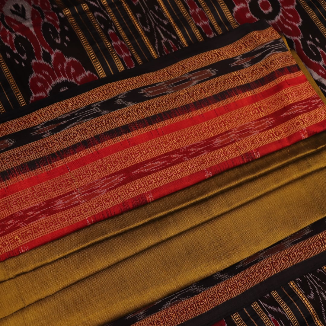 Green and black Khandua silk saree draped; showcasing its butta pattern and elegant fall.