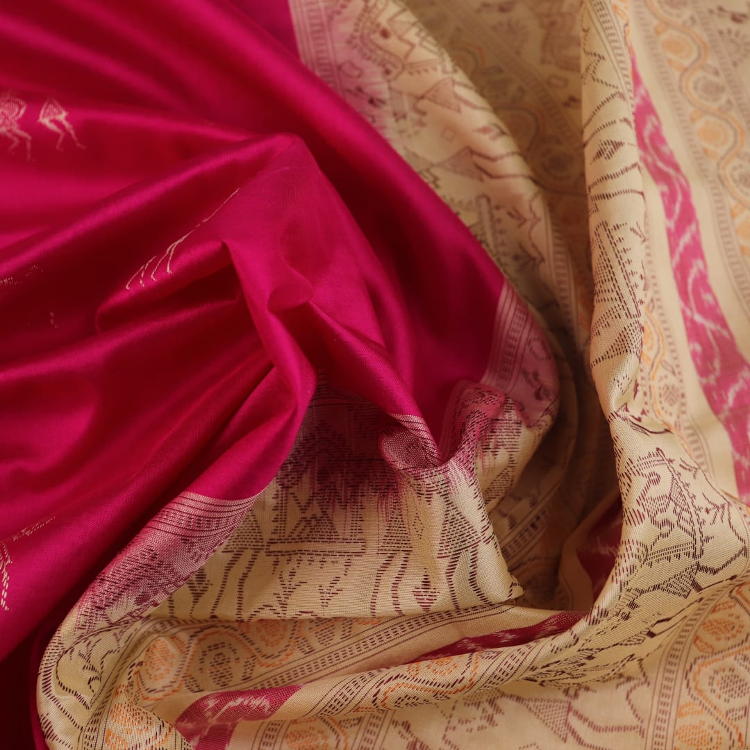 Close-up texture of pink and cream handloom Bomkai silk saree with butta pattern.