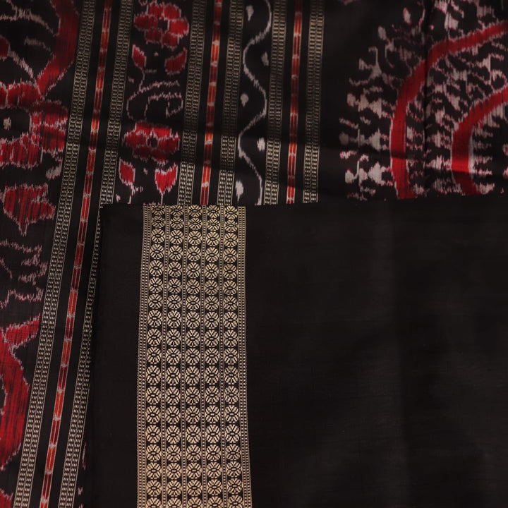 Close-up of handloom Sambalpuri silk saree fabric texture; white with subtle black motifs.