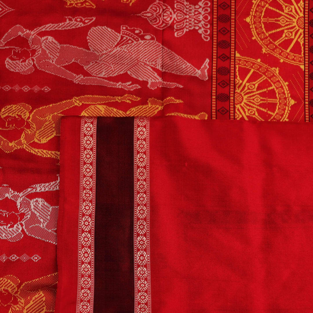 Close-up of Bomkai silk saree fabric texture in black and red, detailing the woven butta pattern.