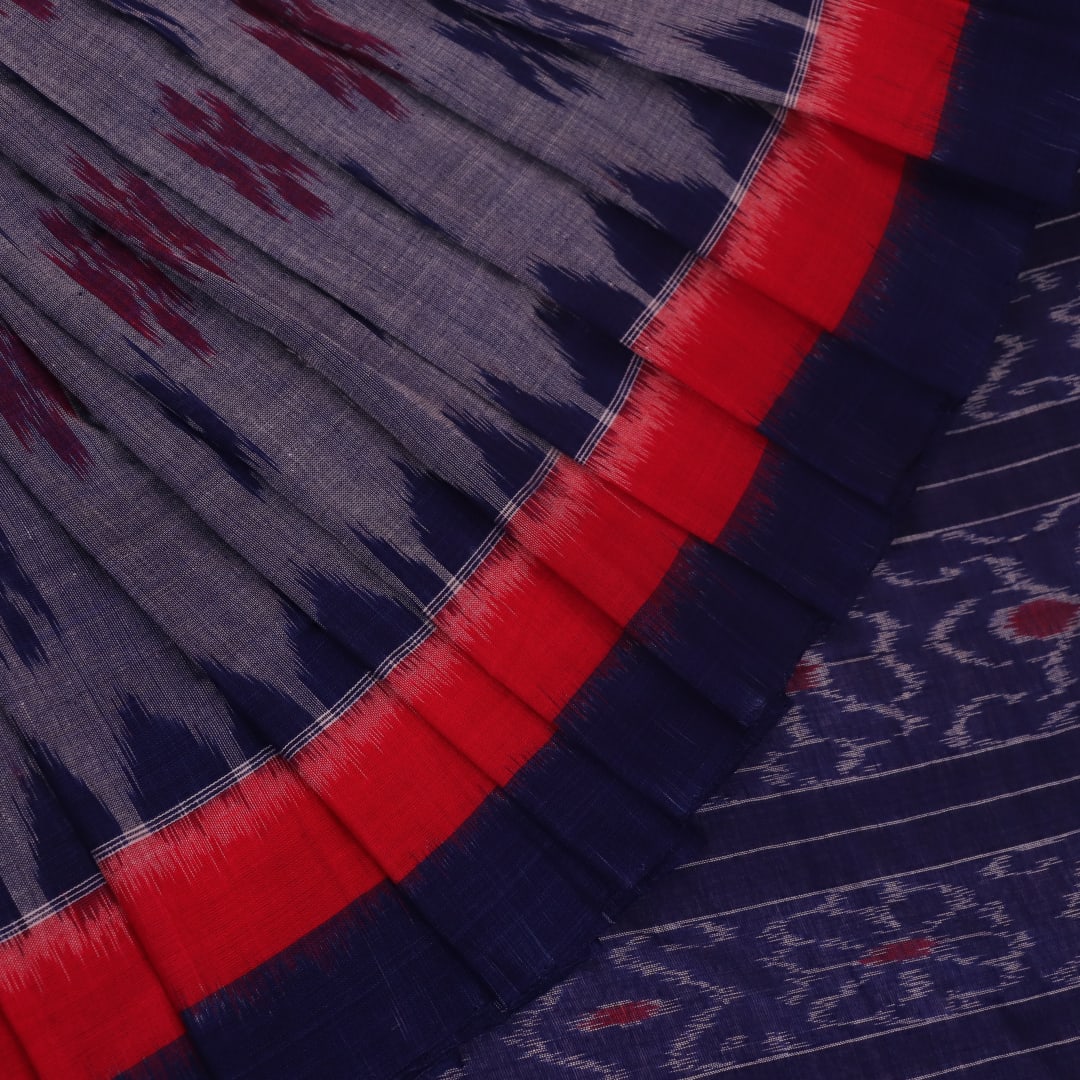 Blue Sambalpuri cotton saree with motifs, gracefully draped.