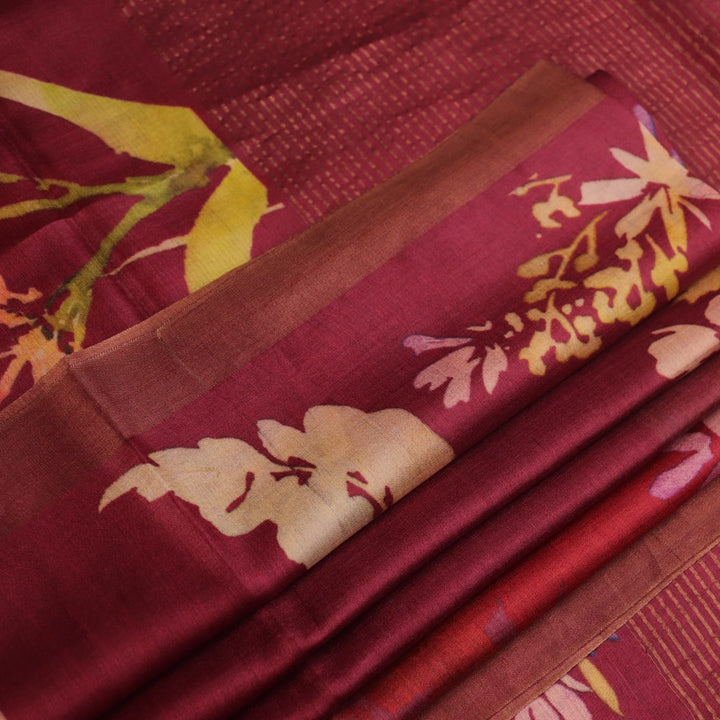Close-up of maroon Tussar silk saree fabric, emphasizing its distinct texture and printed pattern.