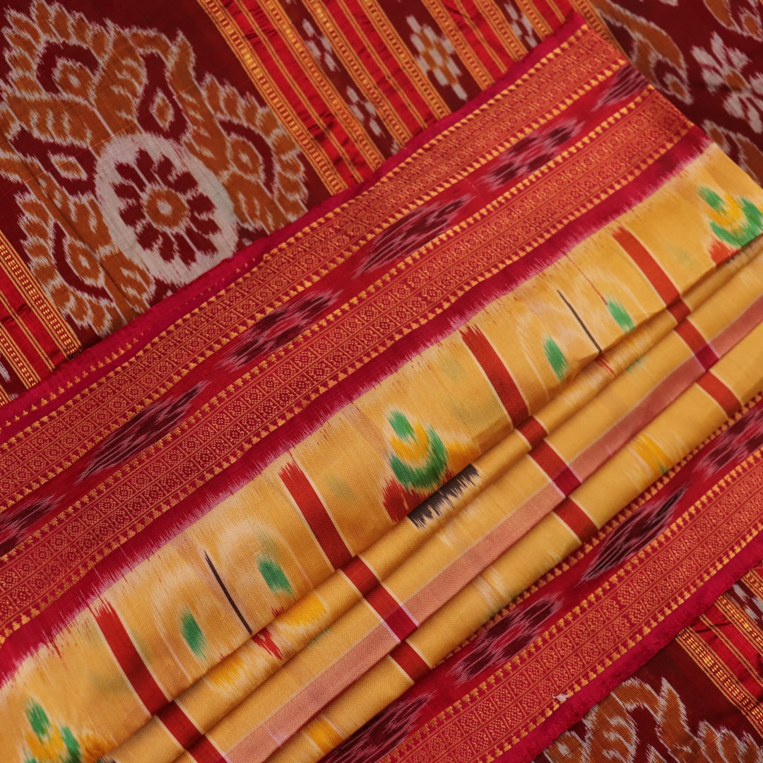 Saree draped to showcase the Nabakothi pattern, red border, and multi-colored silk Khandua handloom artistry.