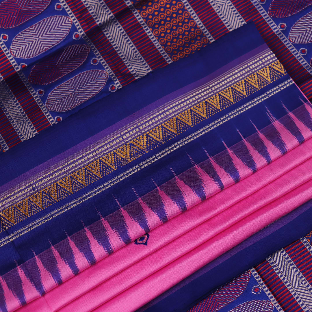 Close-up of pink and blue Dongria Silk Saree fabric texture with butta pattern.