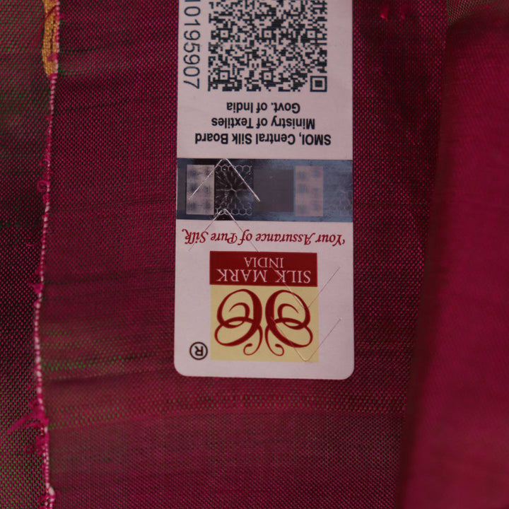 Close-up of magenta Patachitra silk saree fabric texture showing handloom weave and paint details.