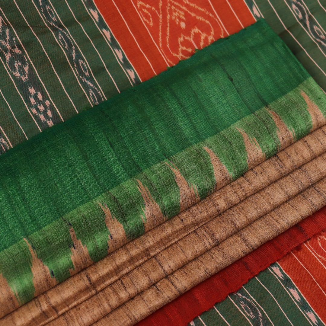 Close-up of plain off-white Tussar silk saree fabric, showing natural slub texture and rust weave.