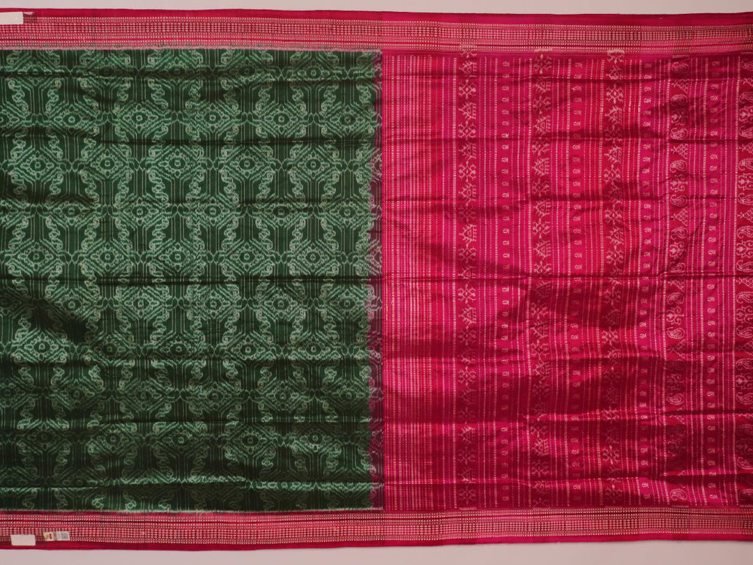 Close-up of textured green Sambalpuri silk saree fabric with magenta motifs.