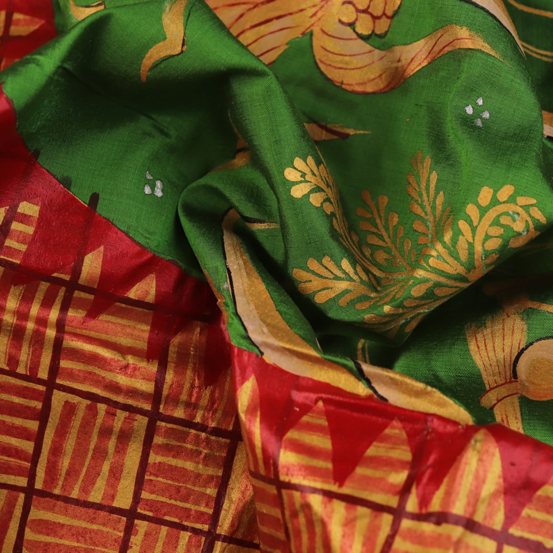 Close-up of green Patachitra silk saree, showcasing the handloom weave and fabric texture.