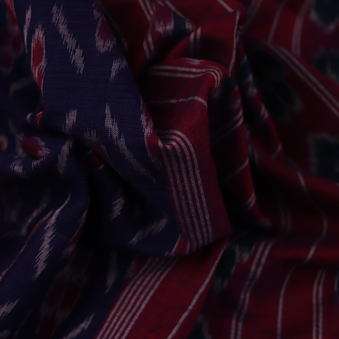 Gracefully draped blue Sambalpuri cotton saree with red motifs, highlighting its design and flow.