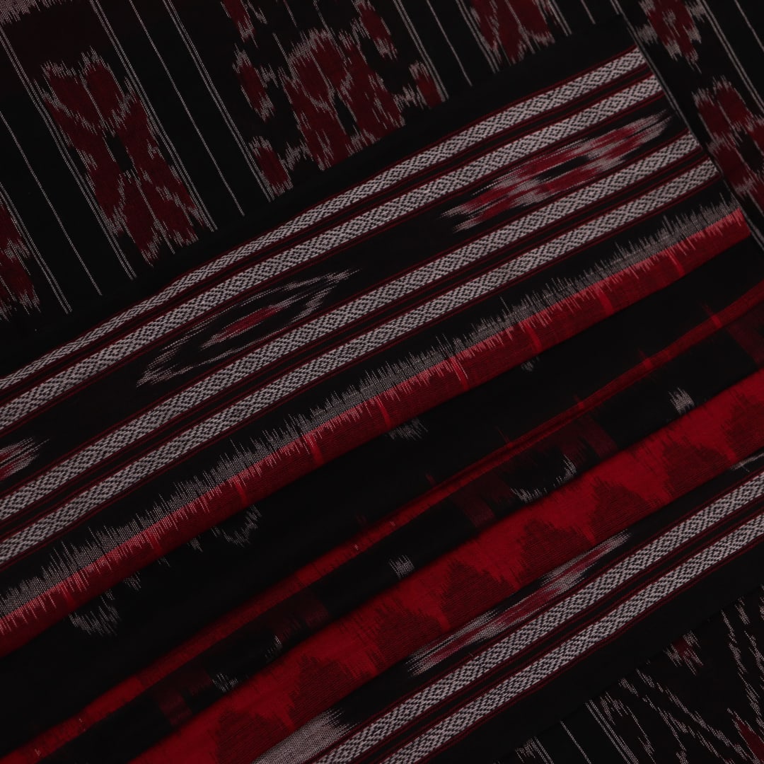Red and black Sambalpuri cotton saree draped, showcasing overall styling and motifs.