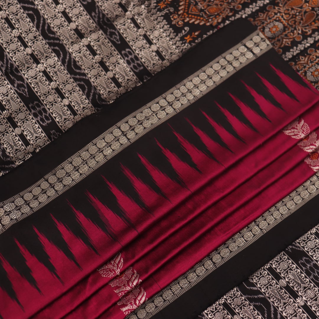 Close-up of magenta and black Bomkai silk saree texture, showing butta pattern weave.