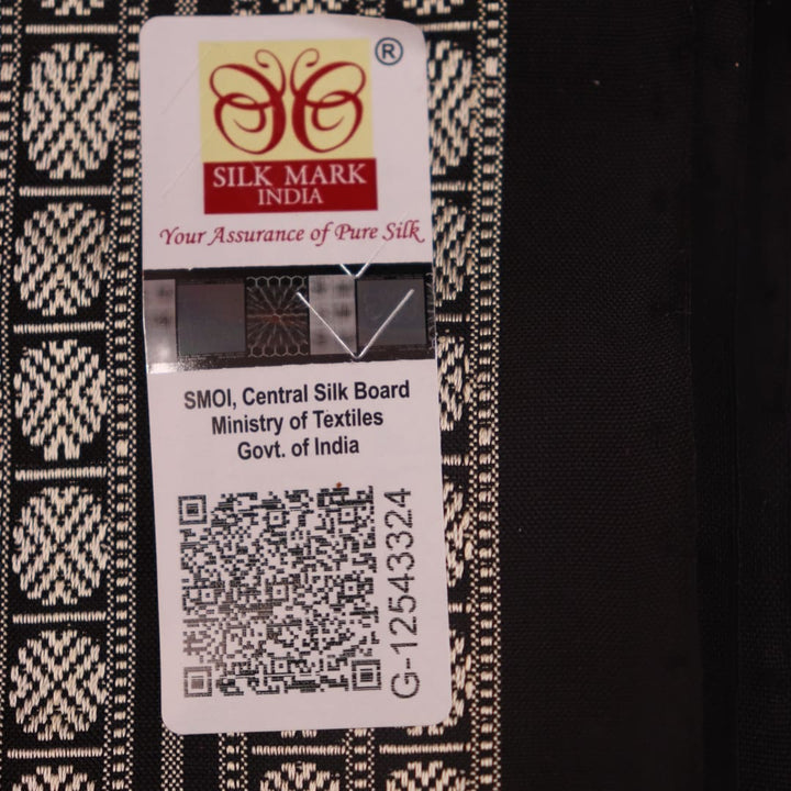 Detailed close-up of the red and black Bomkai silk saree fabric texture, featuring a butta pattern.