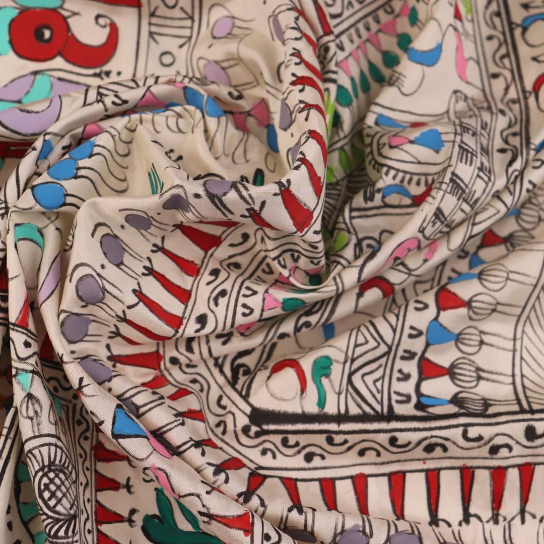 Close-up of the white silk saree fabric texture, showcasing the handloom weave and painted Patachitra details.