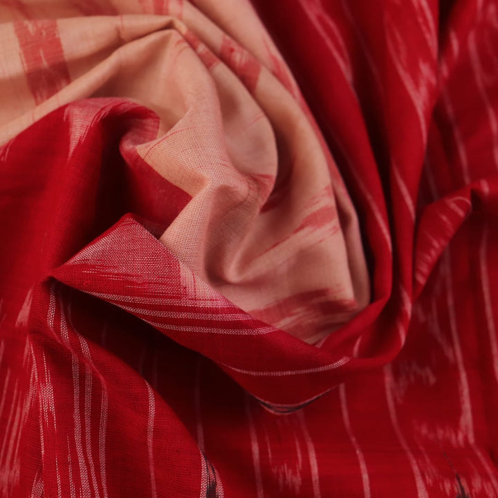 Cream and red Sambalpuri cotton saree with motifs elegantly draped on a person.