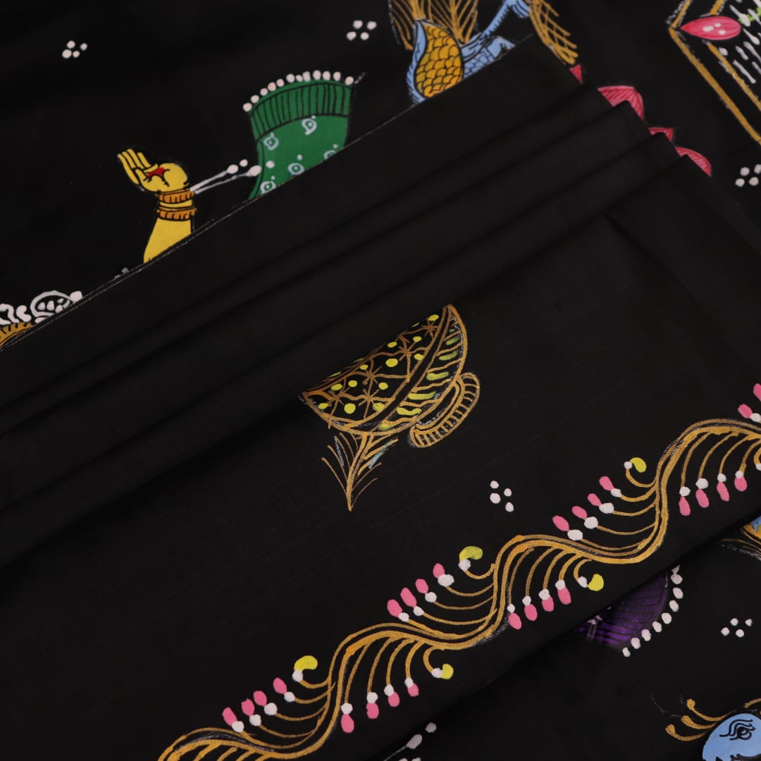 Close-up of black silk Patachitra saree fabric, showcasing hand-painted texture and detail.