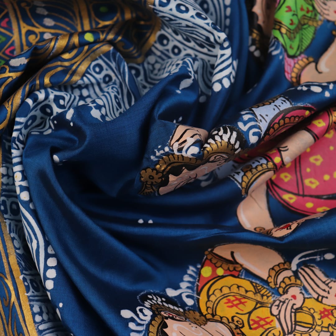 Close-up of handloom blue silk Patachitra saree fabric, showcasing the fine texture and hand-painted details.