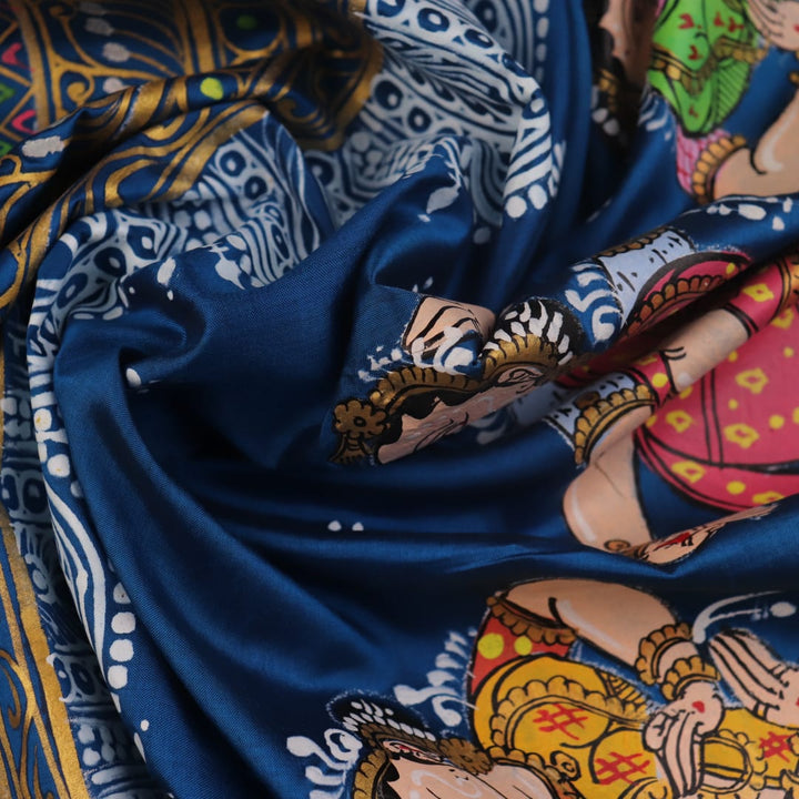 Close-up of handloom blue silk Patachitra saree fabric, showcasing the fine texture and hand-painted details.