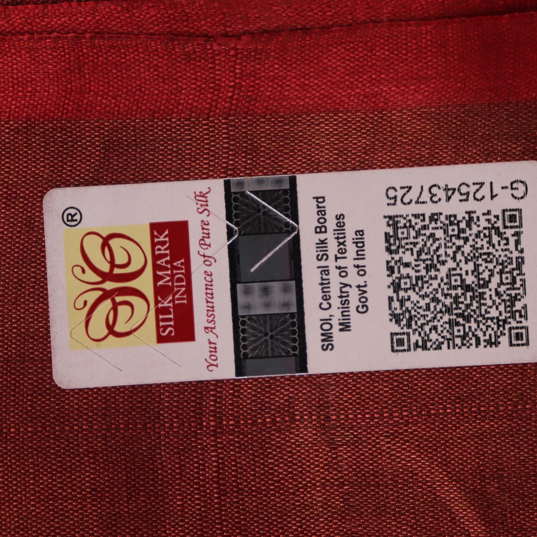 Close-up of the subtle slub and print on a handloom grey and rust Tussar silk saree fabric.