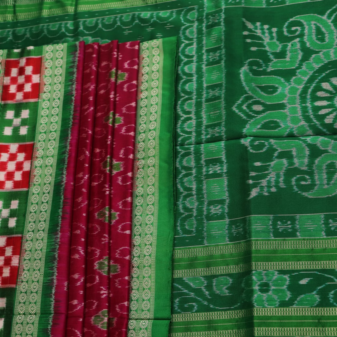 Close-up of magenta Sambalpuri silk saree fabric texture, showcasing intricate handloom weave and subtle motifs.