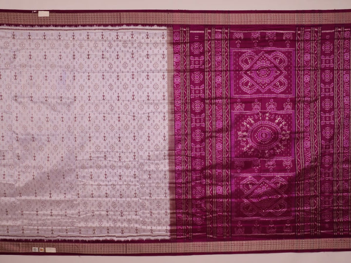 Close-up of silk fabric with intricate Sambalpuri motif design in multicolor and purple hues