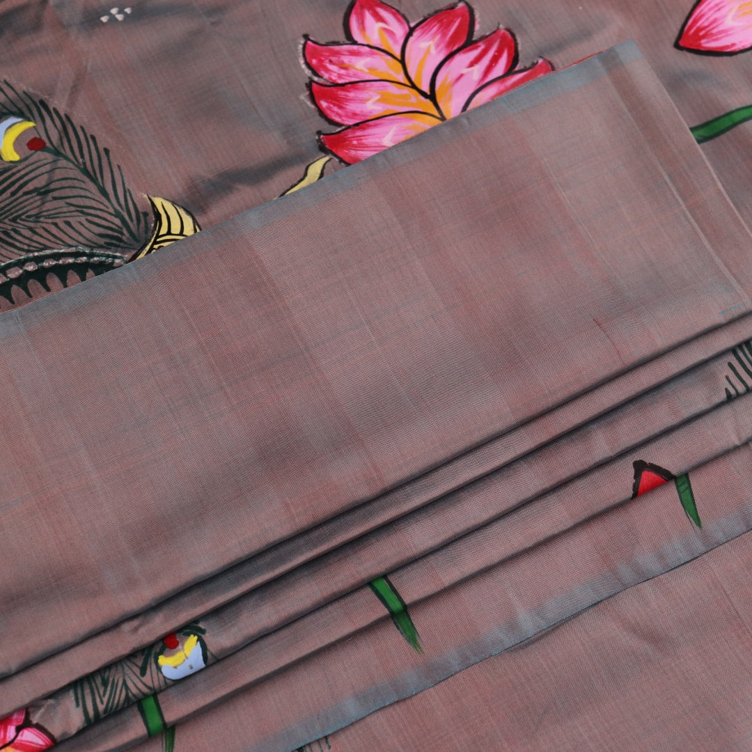 Close-up of hand-painted silk Patachitra saree fabric texture, showing the multicolor details and fine weave.