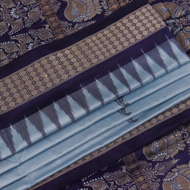 Close-up fabric texture of a blue Bomkai silk saree, revealing intricate butta pattern weave.