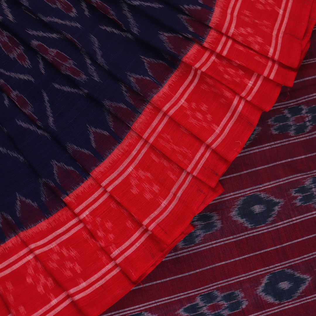Gracefully draped blue Sambalpuri cotton saree with red motifs, highlighting its design and flow.