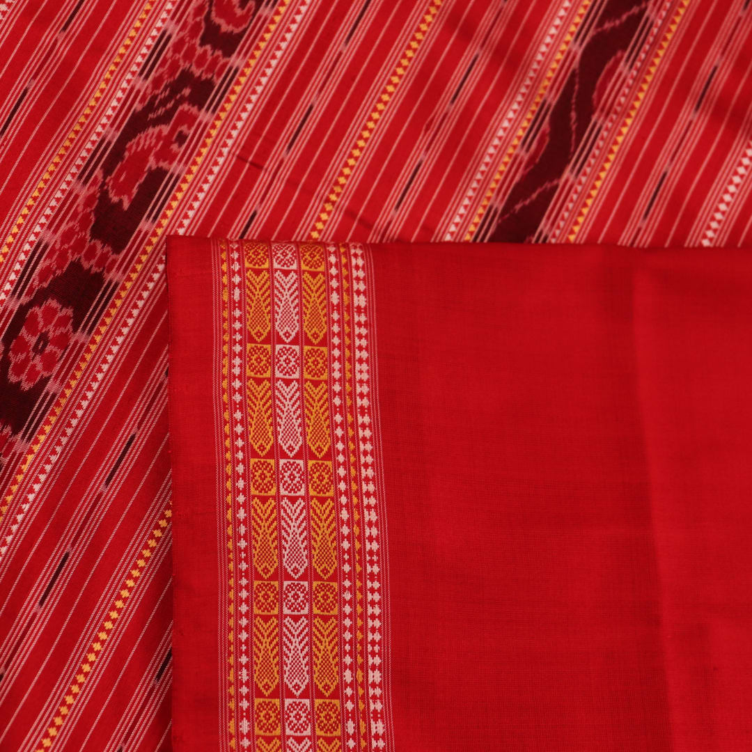 Close-up of the distinct handwoven texture of a red Sambalpuri silk saree with Butta pattern.