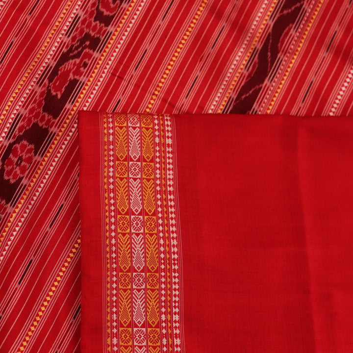 Close-up of the distinct handwoven texture of a red Sambalpuri silk saree with Butta pattern.