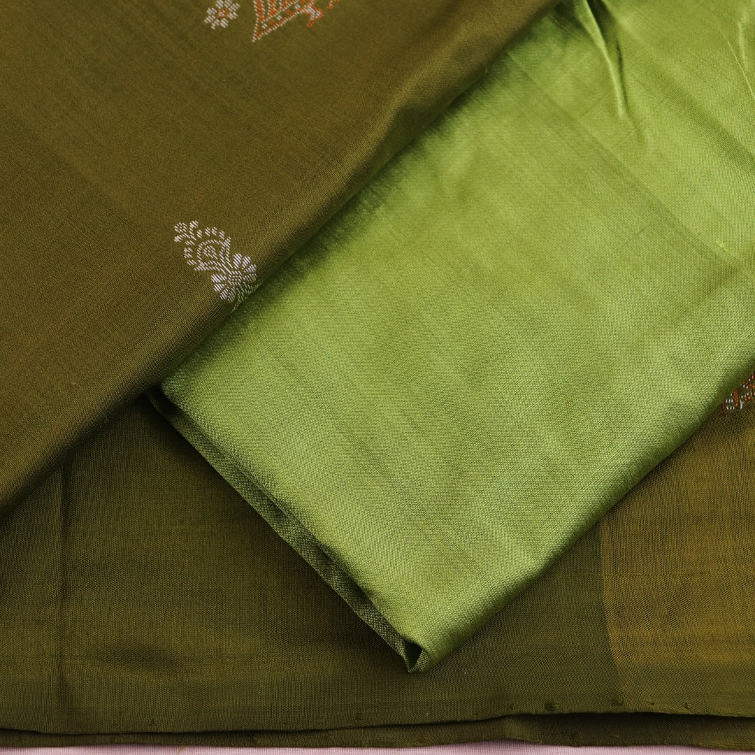 Close-up of the green Bomkai silk dress material's blouse piece with butta pattern.