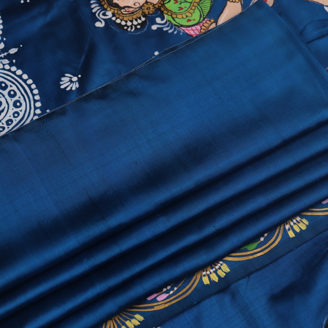 Close-up of handloom blue silk Patachitra saree fabric, showcasing the fine texture and hand-painted details.