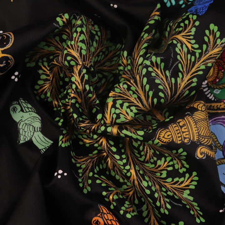 Close-up of black silk Patachitra saree fabric, showcasing hand-painted texture and detail.