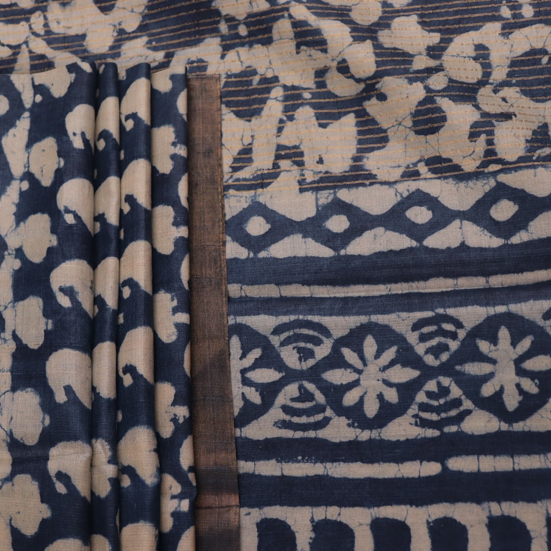 Close-up of blue printed Tussar silk saree fabric texture.