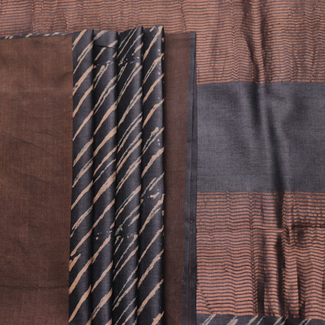 Close-up of the natural slub texture of grey printed Tussar silk saree fabric.
