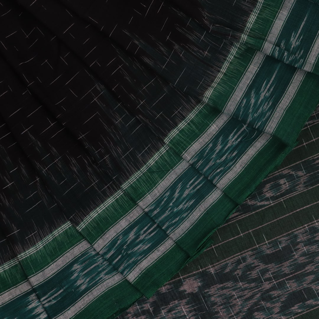 Black and green plain Sambalpuri cotton saree, gracefully draped.