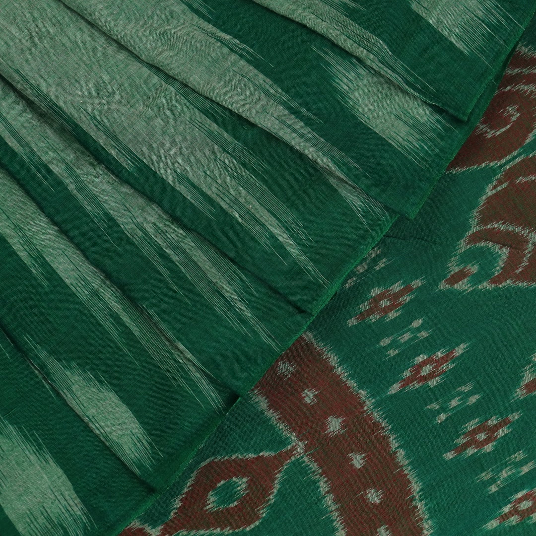 Model wearing a plain green Sambalpuri cotton saree, elegantly draped.