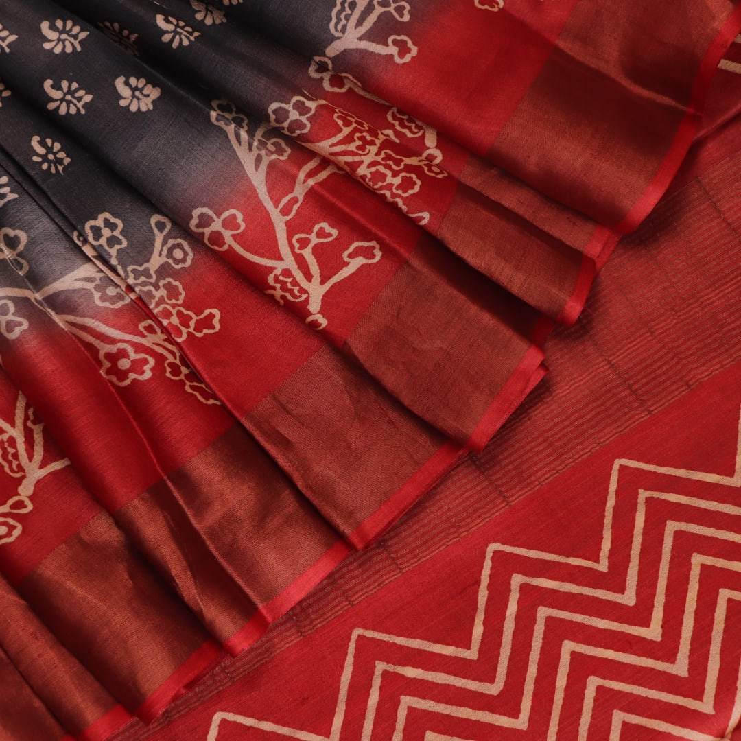 Close-up of the subtle slub and print on a handloom grey and rust Tussar silk saree fabric.