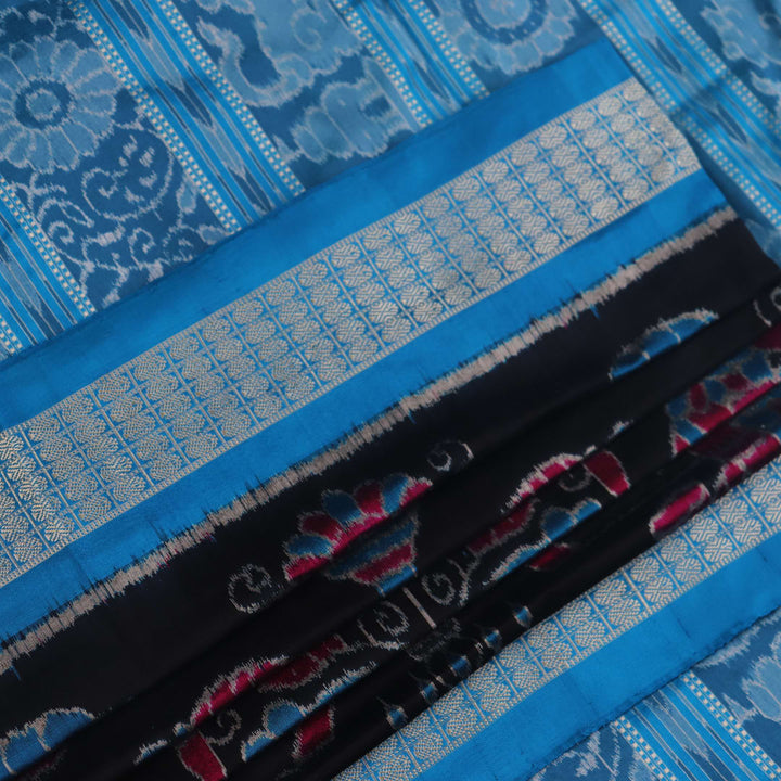 Close-up of black Sambalpuri silk saree fabric texture, showcasing the weave and subtle motif details.