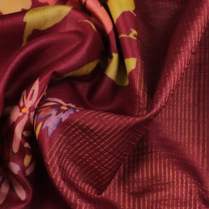 Close-up of maroon Tussar silk saree fabric, emphasizing its distinct texture and printed pattern.