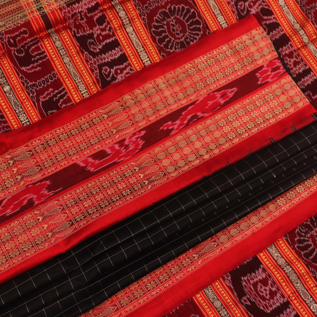 Close-up of black and red striped Sambalpuri silk saree's woven texture.