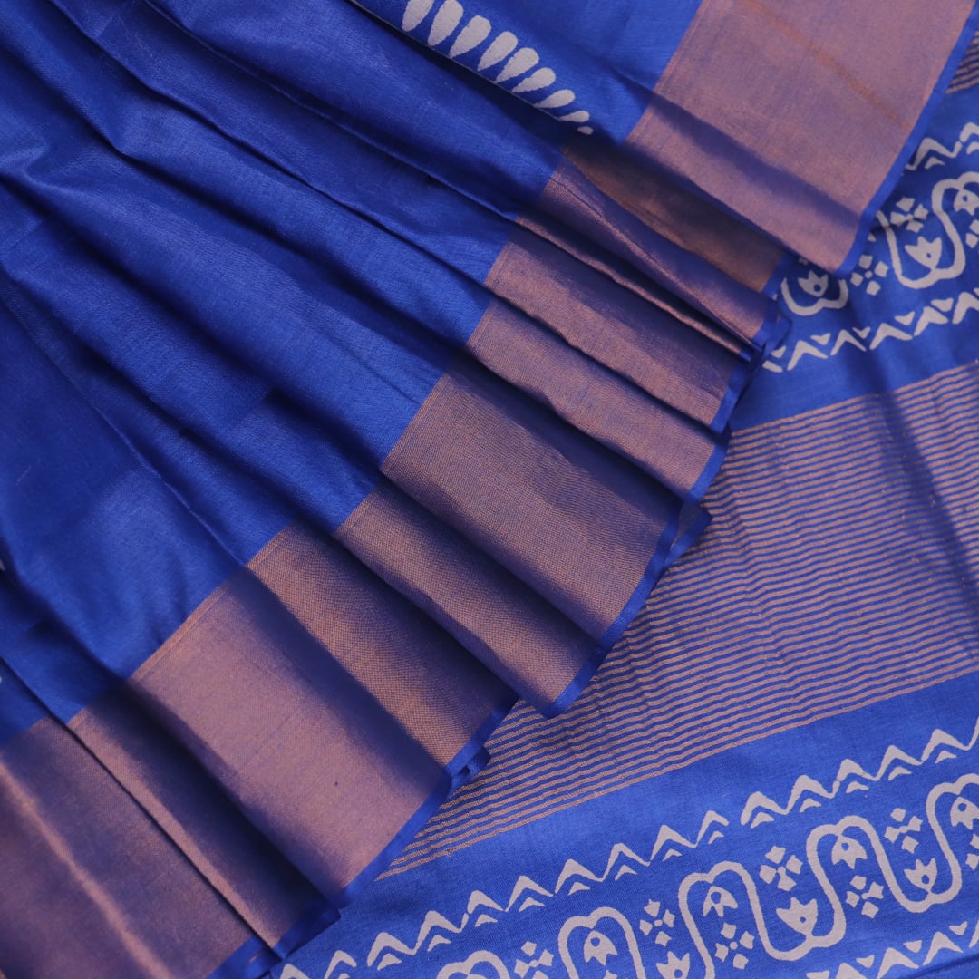 Close-up of blue printed Tussar silk handloom saree fabric texture.