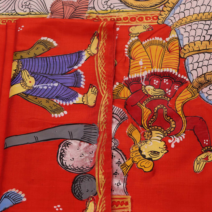 Close-up of red Patachitra silk saree fabric showing hand-painted texture.