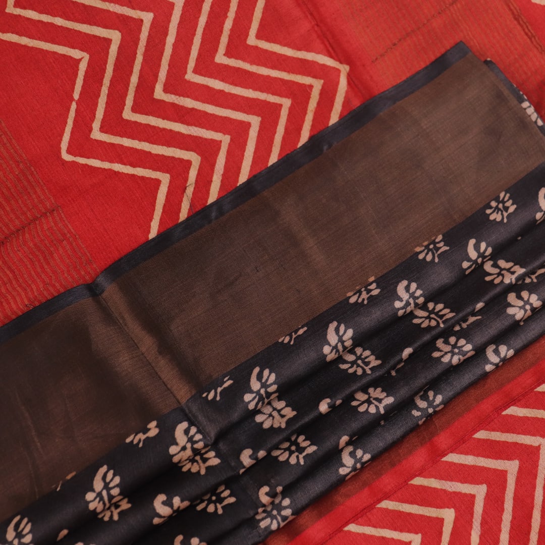 Close-up of the subtle slub and print on a handloom grey and rust Tussar silk saree fabric.