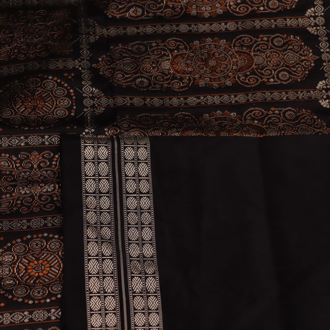 Detailed close-up of the red and black Bomkai silk saree fabric texture, featuring a butta pattern.
