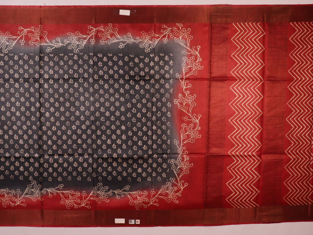 Close-up of the subtle slub and print on a handloom grey and rust Tussar silk saree fabric.