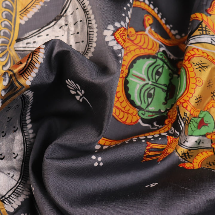 Close-up of handloom grey silk Patachitra saree fabric texture, revealing the intricate details of the hand-painted design.