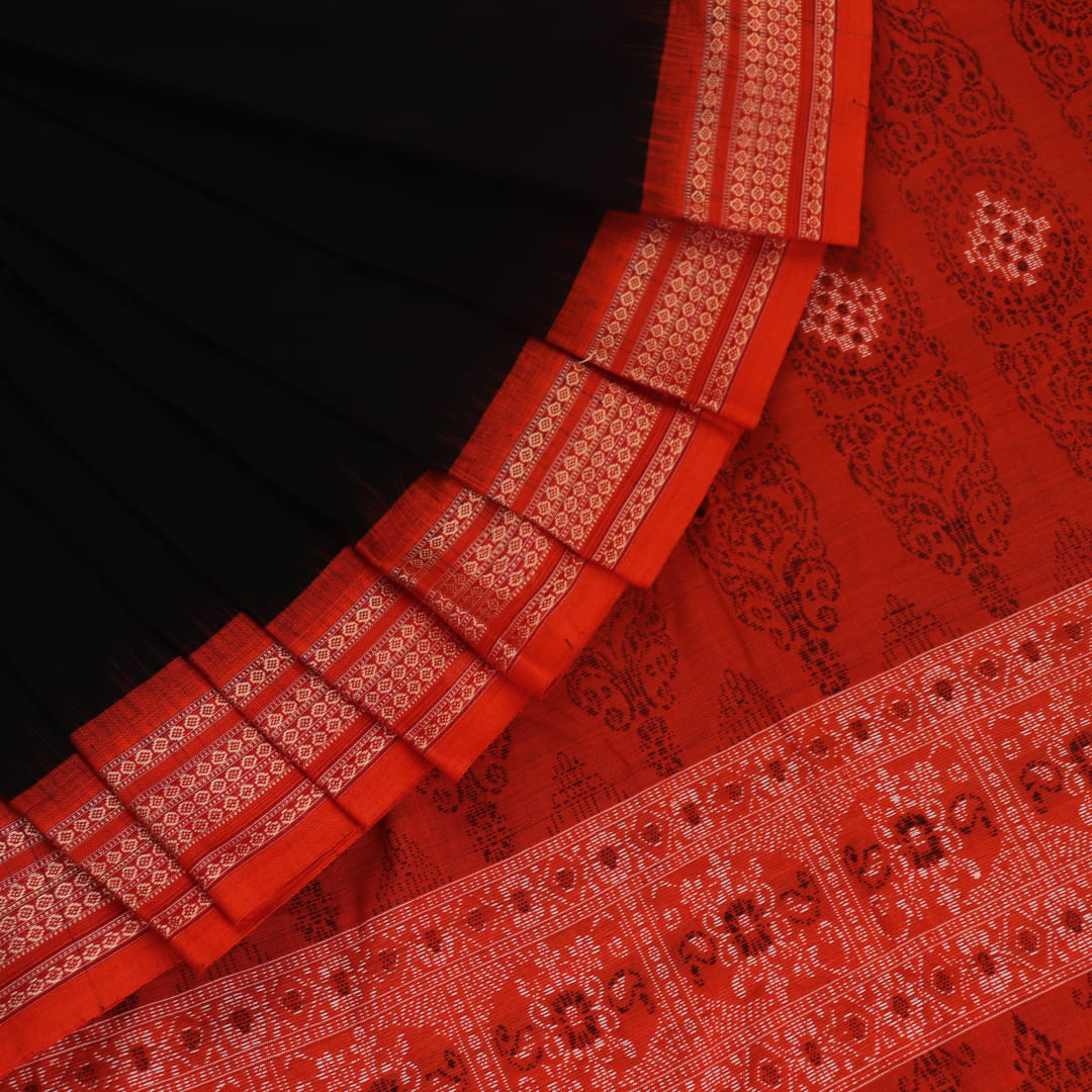 Full view of a black and orange Bomkai cotton handloom saree with butta pattern.
