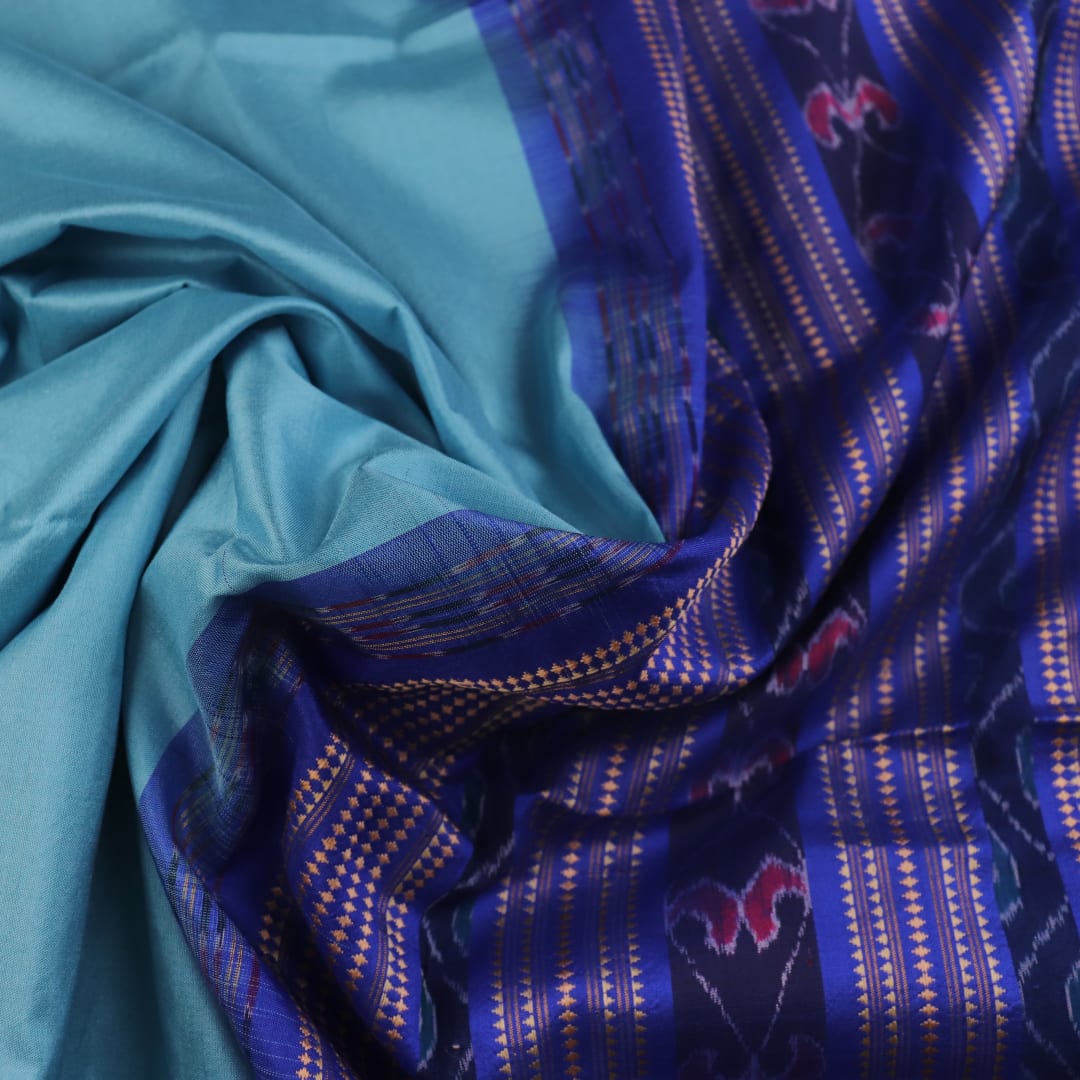 Close-up of plain blue Sambalpuri silk handloom saree fabric texture.